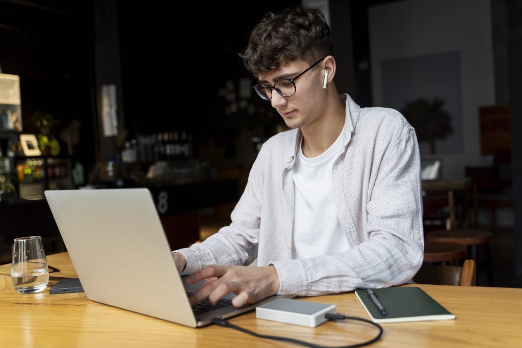 medium shot man typing laptop